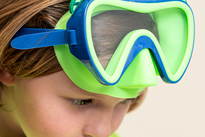 kids posing wearing creature green kids' swim mask showing green nose piece and blue colors and silicone fins with dragon scale inspired texture