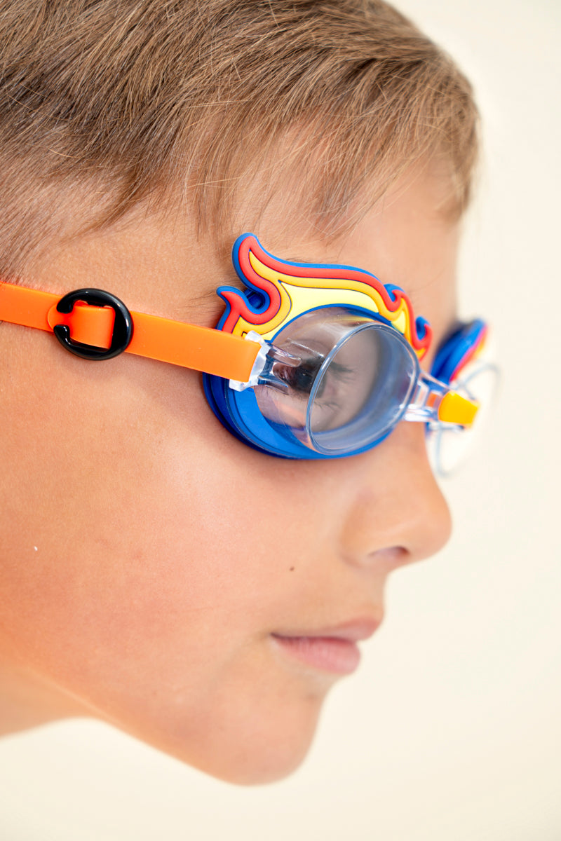 close up image of boy wearing mini flame kids swim goggles showing silicone flame detail on a blue swim goggles with an orange strap and nose piece