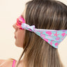 girl modeling soft strap coastal pink kids swim goggles which feature a turquoise colored soft strap with pink and purple coastal decorations such as seashells and starfish this shot features the soft strap fanned out across the back of the head