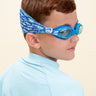 boy wearing soft strap shark blue kids swim goggles which feature a soft strap fanned out across the back of his head. the swim goggles feature a blue swim goggle and royal blue soft strap with light blue shark silhouettes  